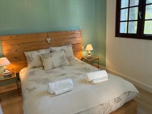 a bedroom with a bed with two towels on it at La villa Les Rosiers en Cévennes in Saint-Martial
