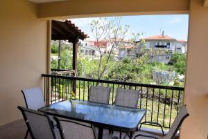 a glass table and chairs on a balcony with a view at Mellonia in Nikiti