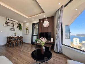 a living room with a table and a large window at La Maison HUD building 2beds in Nha Trang