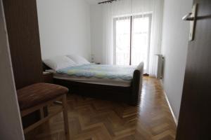 a small bedroom with a bed and a window at Apartman Ljubica in Punat