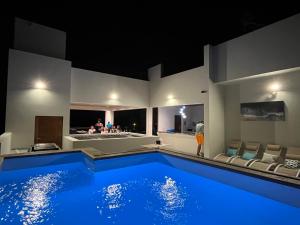 ein großer Swimmingpool in einem Haus mit Personen in einem Zimmer in der Unterkunft Boutique Hotel Luz da Lua in Ponta do Sol
