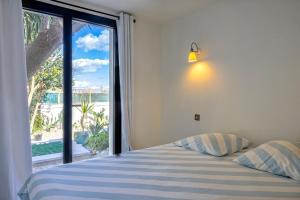 ein Schlafzimmer mit einem Bett und einem großen Fenster in der Unterkunft Villa sur la plage Cap Corse in Brando + 38 Fotos