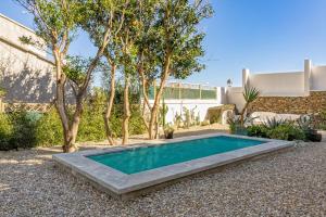 einen Pool in einem Garten mit Bäumen und einem Gebäude in der Unterkunft Villa sur la plage Cap Corse in Brando