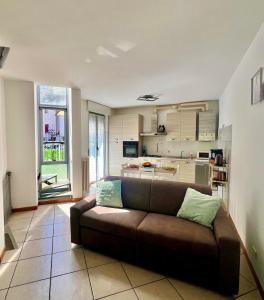 a living room with a brown couch and a kitchen at house poppa in Bellano +36 photos