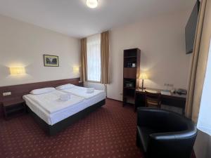 ein Hotelzimmer mit Bett, Schreibtisch und Stuhl in der Unterkunft Memel Hotel in Klaipėda