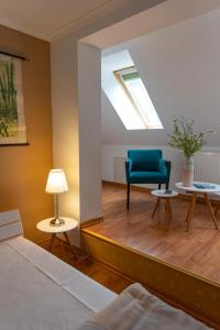 a bedroom with a skylight and a blue chair at Restaurant und Hotel Alte Schule Fürstenhagen in Fürstenhagen
