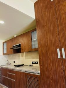 a kitchen with wooden cabinets and a counter top at Skydeck by 2nd Homes in Dehradun