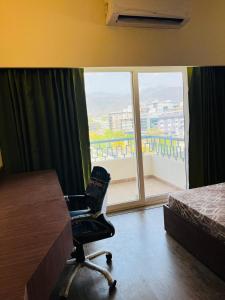 a room with a desk and a chair in front of a window at Skydeck by 2nd Homes in Dehradun +10 photos