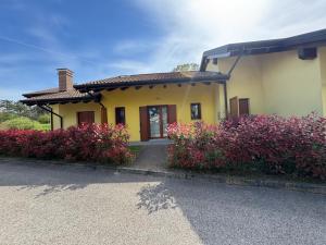 a yellow house with some flowers in front of it at Casabianca Resort Villas in Lignano Sabbiadoro