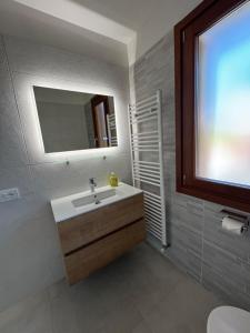 a bathroom with a sink and a mirror and a window at Casabianca Resort Villas in Lignano Sabbiadoro +46 photos