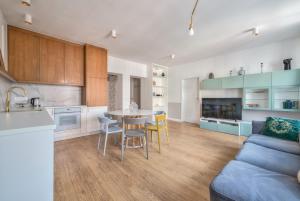 a kitchen and living room with a table and chairs at Old Town Długa by NorthSide Apartments in Gdańsk