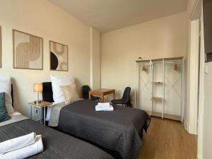 a hotel room with two beds and a desk at TT Living Apartments BONITAS & DIVINITAS I 2 Schlafzimmer I Küche I Vollbad I Waschmaschine in Rellingen