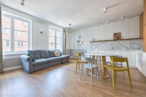 a living room with a couch and a table and chairs at Old Town Długa by NorthSide Apartments in Gdańsk +17 photos