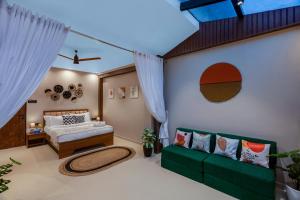 a bedroom with a green couch and a bed at SaffronStays Episode in Jāmb +20 photos