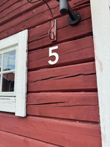 une maison rouge avec un numéro dessus dans l'établissement Cottage in quiet natural surroundings, à Ramsjö