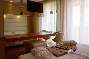 a hotel room with a desk and a bed with towels at AmbientHotels Panoramic in Rimini