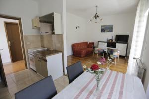 a kitchen and living room with a table and chairs at Apartman Ljubica in Punat