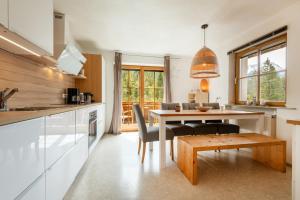 a kitchen and dining room with a table and chairs at Schneehaus Chalet in Ehrwald