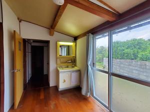 an empty room with a large window and a sink at 一棟貸し 喜瀬しーばなゲストハウス -Traditional House Rent- in Amami