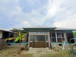a small house with a green roof at 一棟貸し 喜瀬しーばなゲストハウス -Traditional House Rent- in Amami