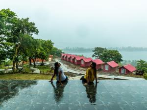 班达尔达拉The Hosteller Bhandardara的两名妇女站在房屋前的水中