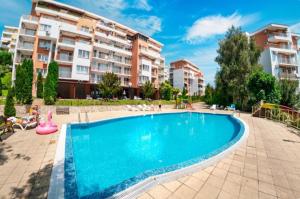 an apartment with a swimming pool in front of some buildings at Golden Lady in Sveti Vlas