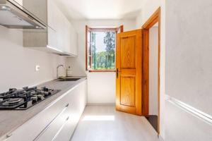 a small kitchen with a stove and a window at Golf House - Valle Christi in Rapallo
