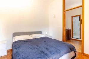 a bedroom with a large bed with a blue blanket at Golf House - Valle Christi in Rapallo