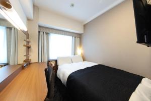 a hotel room with a bed and a television at APA Hotel Tennoji Ekimae in Osaka