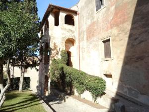 Un edificio con hiedra creciendo en el costado. en La Casa del Faro, en Porto Ercole