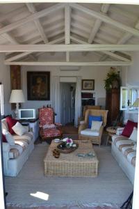 Una gran sala de estar con sofás y una mesa. en La Casa del Faro, en Porto Ercole