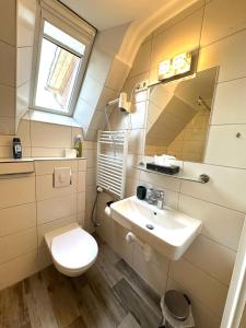 a bathroom with a toilet and a sink at Pension im Heidort in Oyten +40 photos