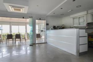 una cucina con bancone bianco e una sala da pranzo di Hotel Playa a Cangas de Morrazo