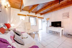 a living room with a couch and a television and a desk at Les Hortensias in Hillion