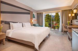 a hotel room with a large bed and a desk at Rixos Premium Tekirova - The Land of Legends Access in Tekirova