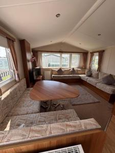 a living room with a table and a couch at Sunshine caravans in Eastchurch