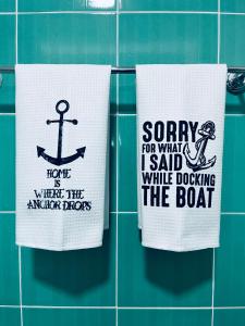 three towels on a tiled wall with words on them at Seaside Serenity! FREE PARKING! in Sarandë