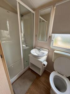a small bathroom with a toilet and a sink at Sunshine caravans in Eastchurch