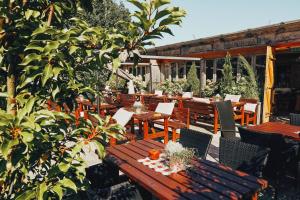 un patio al aire libre con mesas y sillas de madera en Sportalm Gipfelglück, en Lüdenscheid