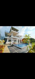 un grand bâtiment avec une piscine devant dans l'établissement Villa Istana Fitri, à Situ 2