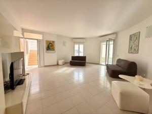 a living room with two couches and a tv at iDream on the sea in Punta Braccetto