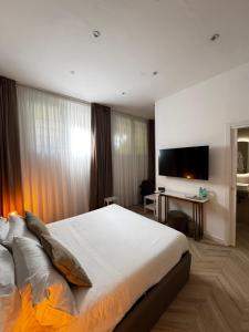 a bedroom with a large bed and a flat screen tv at NapoliOn - Luxury Apartment in Naples
