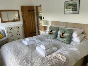 a bedroom with a bed with towels on it at Gardeners Cottage in Mudford