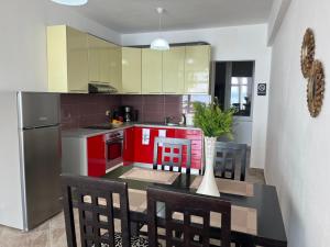 a kitchen with red cabinets and a table with chairs at Seaside Serenity! FREE PARKING! in Sarandë