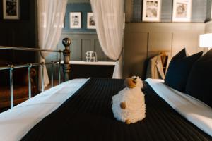 un animal farci est assis sur un lit dans l'établissement Sheddington Manor - 2 Bedroom Guest House & Cinema, à Belfast 38 autres photos
