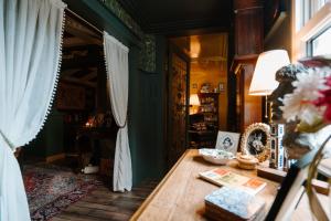 Cette chambre dispose d'une table en bois et d'une fenêtre. dans l'établissement Sheddington Manor - 2 Bedroom Guest House & Cinema, à Belfast