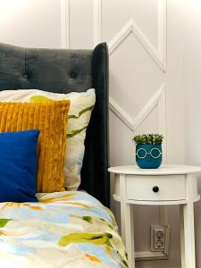 a bed with a white night stand next to a side table at Central ZEN apartament in Cluj-Napoca