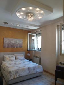 a bedroom with a large bed and a chandelier at Adagio 7 in Belgrade
