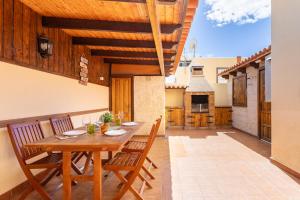 Un comedor con mesa y sillas de madera. en Villa Luxury with pool Tenerife, en Las Galletas