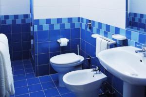 a blue tiled bathroom with a toilet and a sink at Bed & Breakfast Isola Bella Lampedusa in Lampedusa